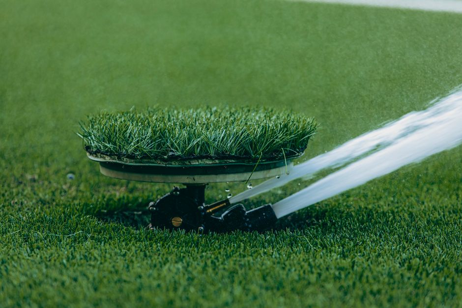 Watering a newly installed green lawn and garden beds